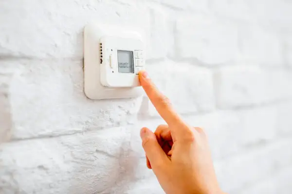 Ajustando el termostato para unos agradables grados calefaccion invierno.